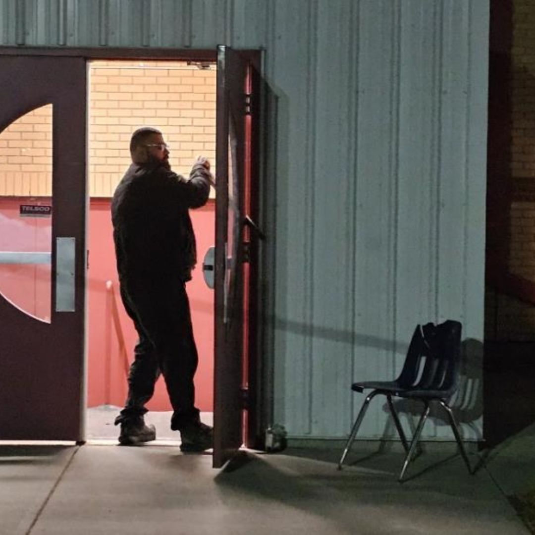 Peacekeeper conducts a security check on an unsecured building entrance during a night foot patrol, December 2025